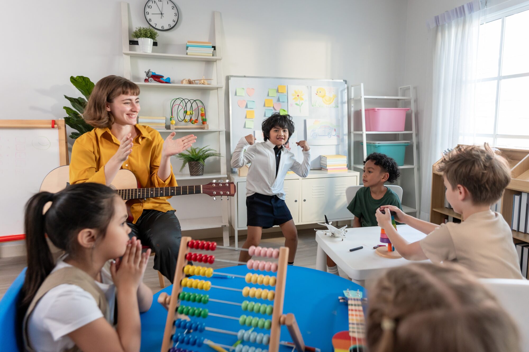 Caucasian,Young,Woman,Teacher,Playing,Guitar,With,Students,In,School.